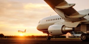Plane on a runway with a plane taking off in the background