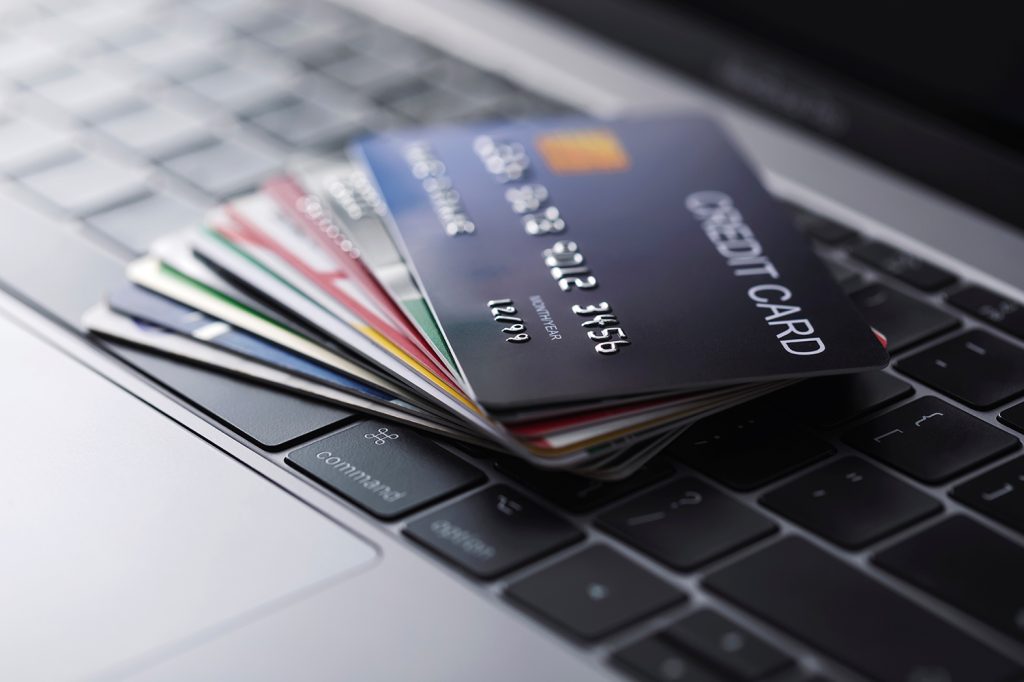 stack of credit cards on a laptop keyboard