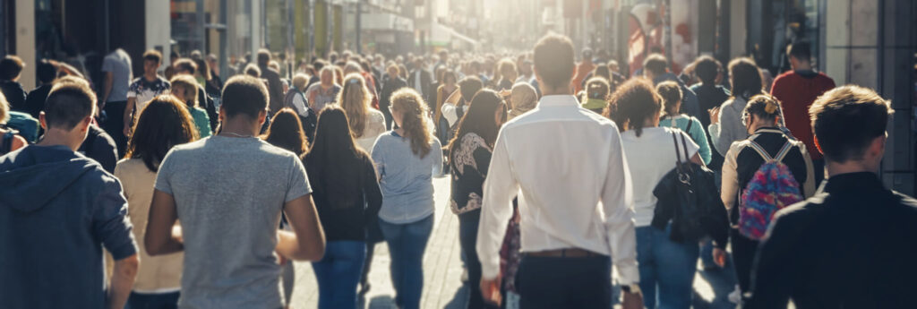 crowd of people walking through a shopping area